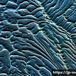 강재 열처리 성공 사례 - A detailed close-up of a steel sample under a high-powered microscope showing the microstructure tra...